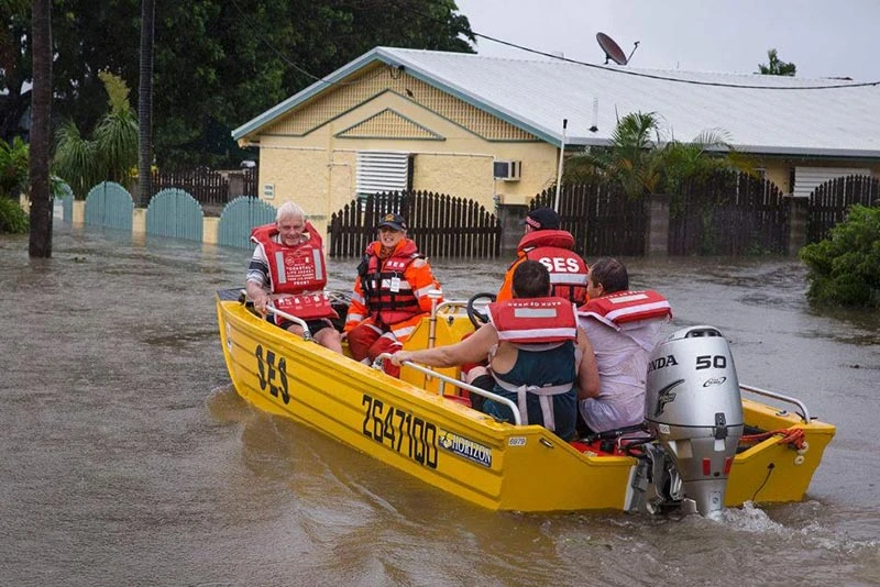 SES workers rescuing residents by boat during Townsville floods in Australia, supported by Pryme safety initiatives.