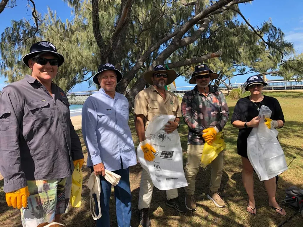 Group of volunteers participating in Clean Up Australia Day with Pryme-branded bags.