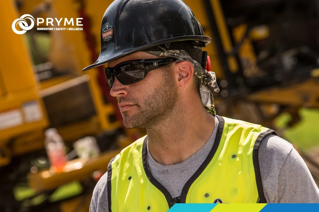 Worker wearing hard hat, sunglasses, and high-visibility cooling vest under bright sunlight.