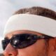 Worker wearing white Ergodyne Chill-Its 6650 cotton sweatband for sweat absorption and comfort outdoors.