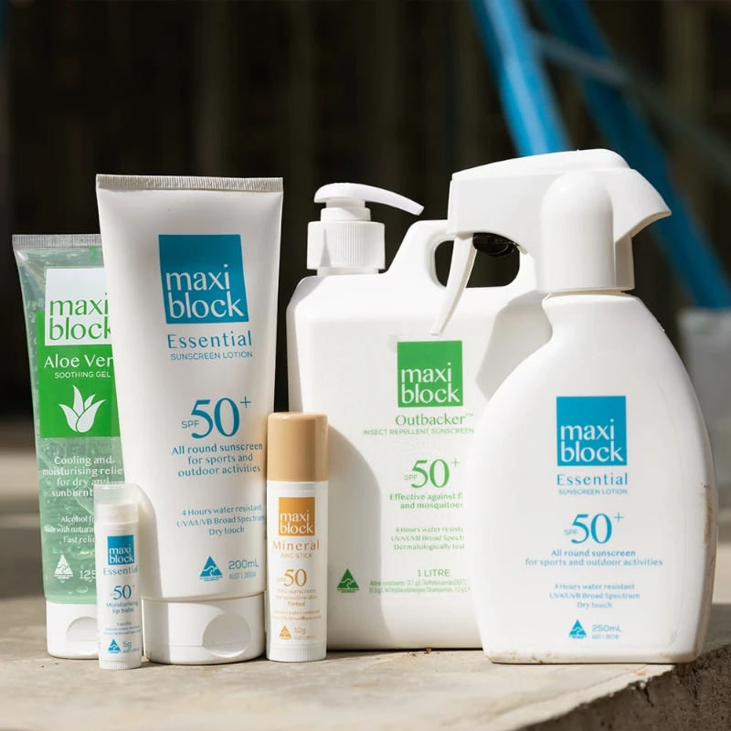 Collection of Maxiblock Essential, Outbacker, Mineral, and Aloe Vera sun protection products on outdoor surface.