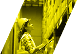 Worker in hard hat inspecting shelves in warehouse, stylised in yellow Pryme brand overlay.